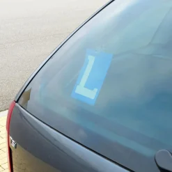 Blauw bordje met witte L voor lesvoertuigen